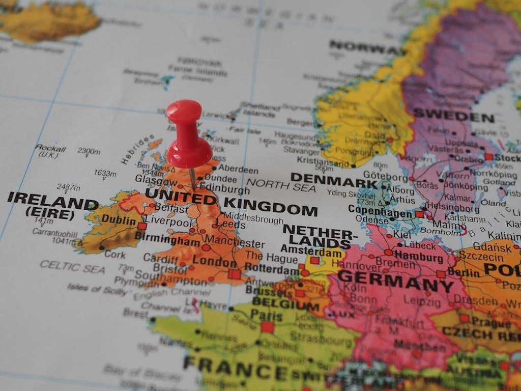 Close-up of a European map highlighting the UK with a red pin, perfect for geography themes.