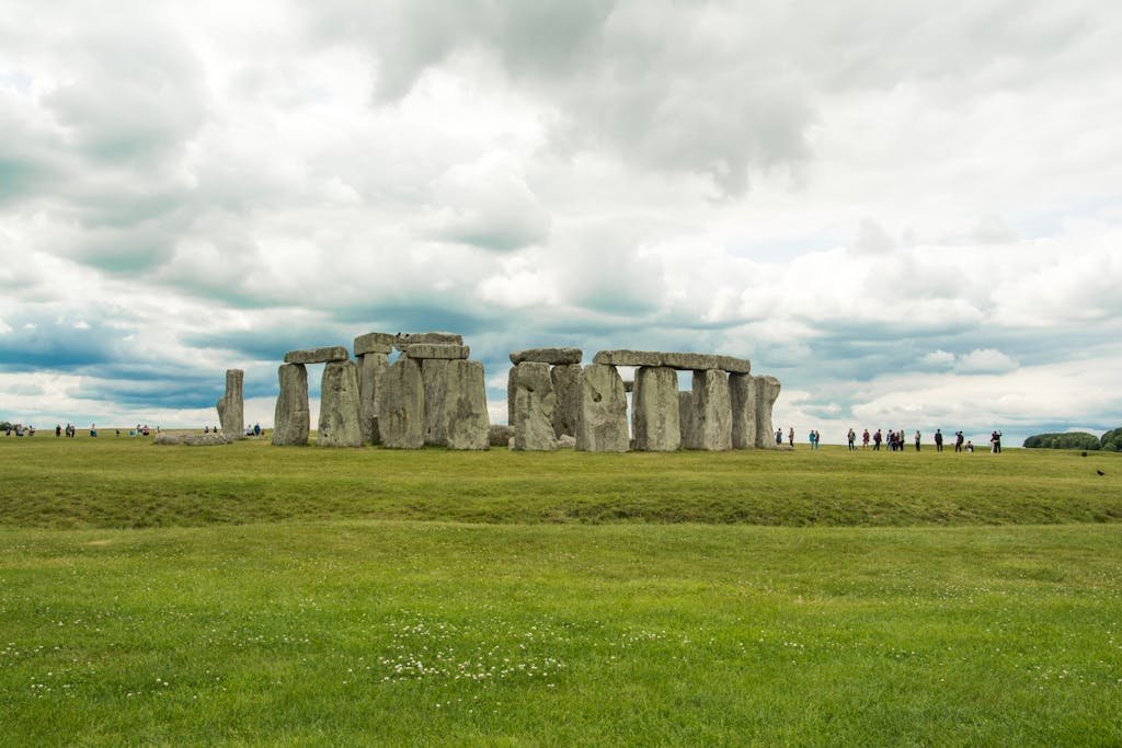 Stonehenge with tourists under cloudy skies showcasing the iconic landmark in England.